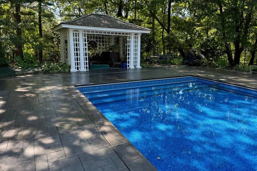 After: the same pool deck sealed, deep charcoal color