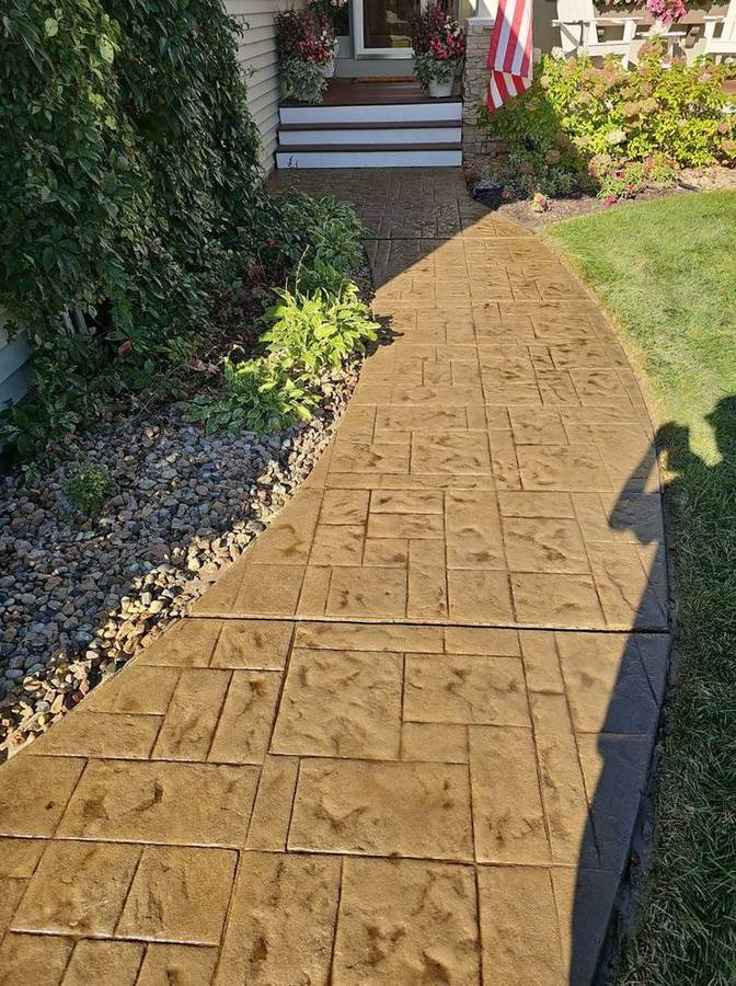After: the same walkway sealed, with rich golden color