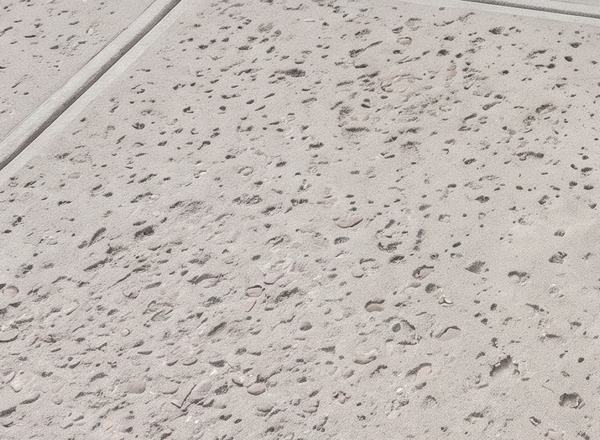 Concrete surface with pop-outs and pitting exposing the stone underneath